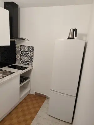 a kitchen with a white refrigerator with a lamp on top at Bel appartement in Nice