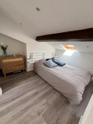 a bedroom with a large bed and a wooden floor at Cocon lumineux sous les toits de Nice in Nice
