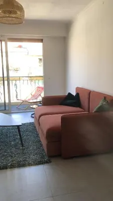 a living room with a brown couch and a table at Port of Nice Terrace Apartment in Nice