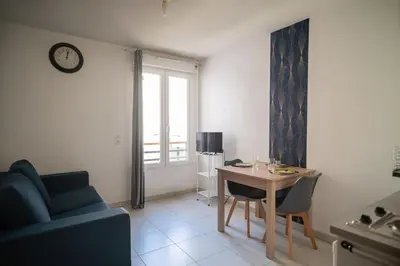 a living room with a table and a blue couch at Bail mobilité - Beau studio proche tram Saint-Roch in Nice