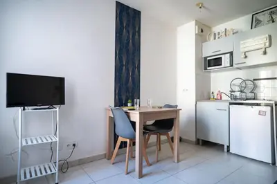 a small kitchen with a table and a television in a room at Bail mobilité - Beau studio proche tram Saint-Roch in Nice