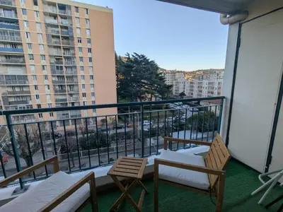 a balcony with two chairs and a view of a city at Nice Cosy Garden in Nice