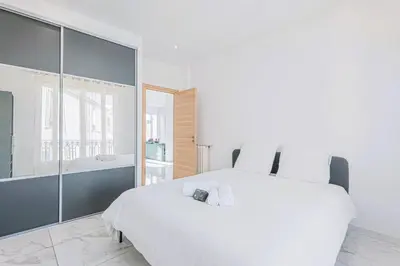 a white bedroom with a large bed and a tub at Bail mobilité - Appartement 2 ch - Nice centre in Nice