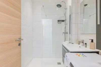 a white bathroom with a shower and a sink at Bail mobilité - Appartement 2 ch - Nice centre in Nice