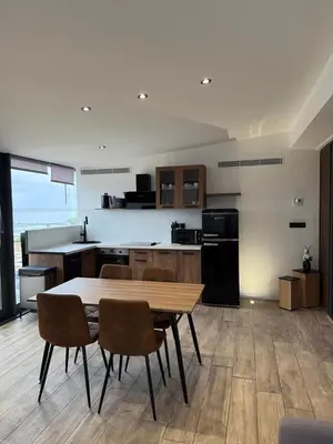 a kitchen with a table and chairs in a room at Nid Azuréen – À deux pas de la plage, 6P in Saint-Laurent-du-Var
