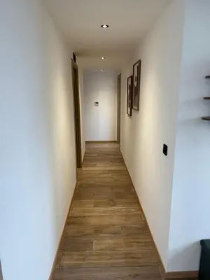 a hallway with white walls and a wooden floor at Nid Azuréen – À deux pas de la plage, 6P in Saint-Laurent-du-Var