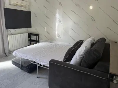 a room with a bed and a couch and a tv at La Casa di Gio studio Cosy Tram et mer in Nice