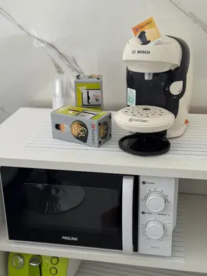 a shelf with a coffee maker and a microwave at La Casa di Gio studio Cosy Tram et mer in Nice