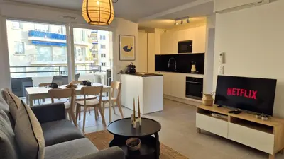 a living room with a couch and a tv and a table at T3 neuf climatisé avec parking à Nice in Nice