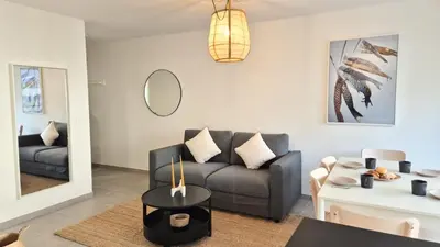 a living room with a couch and a table at T3 neuf climatisé avec parking à Nice in Nice