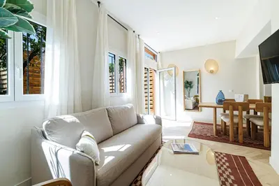 a living room with a couch and a table at 62 CARNOT LOT 2 - Un havre de paix climatise avec jardin et jacuzzi in Nice