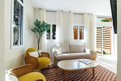 a living room with a couch and a table and chairs at 62 CARNOT LOT 2 - Un havre de paix climatise avec jardin et jacuzzi in Nice