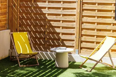 two chairs and a table on a patio at 62 CARNOT LOT 2 - Un havre de paix climatise avec jardin et jacuzzi in Nice