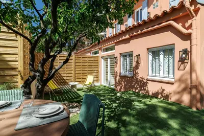 a table and chairs in a yard next to a building at 62 CARNOT LOT 2 - Un havre de paix climatise avec jardin et jacuzzi in Nice