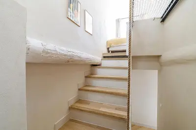a staircase in a house with white walls and wooden floors at 62 CARNOT LOT 7 - Appartement Duplex Atypique- climatise - 2 chambres in Nice