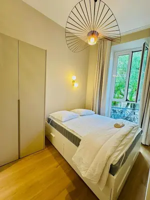 a bedroom with a large bed with a large window at Appartement neuf d architecte Carré d Or in Nice