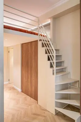 a metal staircase in a room with a wooden door at 2BDR 6P central A C apt - heart of Nice in Nice