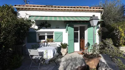 a table and chairs in front of a house at Studio climatisé cosy dans une villa avec parking in Cagnes-sur-Mer