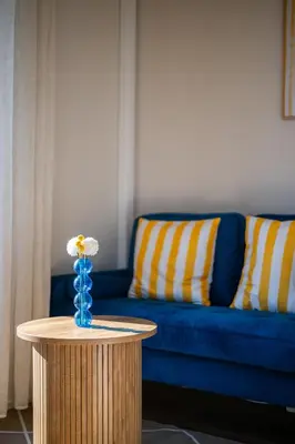 a table with a flower on it next to a couch at Vue mer panoramique - Cocon cosy et luxe - Clim et Wifi in Cagnes-sur-Mer