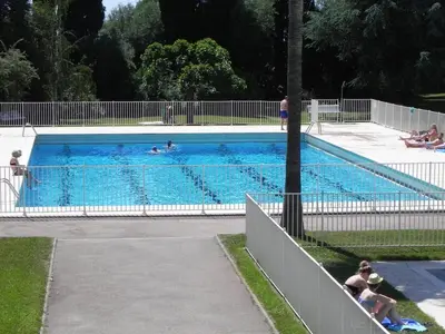 a large swimming pool with people in it at 4 chambres, vue mer, calme in Nice