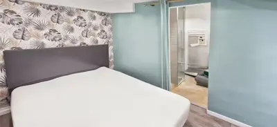 a bedroom with a white bed and a refrigerator at Sunny Old Town Studio in Nice