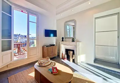 a living room with a fireplace and a table at Nestor&Jeeves - RIVIERA JAURES - Terrace - Close Old Town in Nice