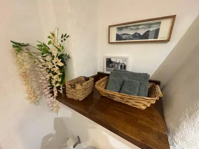 a shelf with two baskets and a vase of flowers at Auberge de la Croix du Pape in Èze