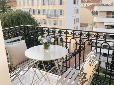 a table on a balcony with a vase of flowers at appartement moderne pour 3 pers Hyper Centre proche Jean Médecin in Nice