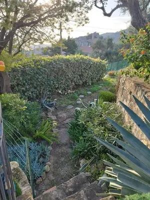 a garden with a fence and a path with plants at Maison de charme piscine vue mer in Èze
