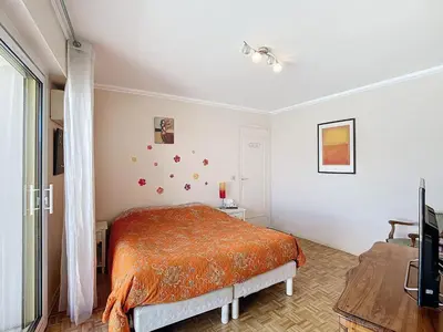 a bedroom with a bed with an orange blanket at Penthouse d'exception avec terrasse panoramique in Nice