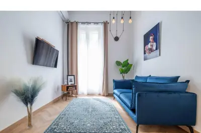 a living room with a blue couch and a tv at Magnifique - 2 chambres - Cœur de Nice avec Balcon in Nice