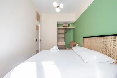 a bedroom with a large bed and a green wall at Magnifique - 2 chambres - Cœur de Nice avec Balcon in Nice