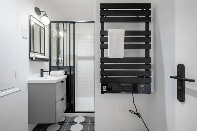 a bathroom with a sink and a black and white floor at Magnifique - 2 chambres - Cœur de Nice avec Balcon in Nice