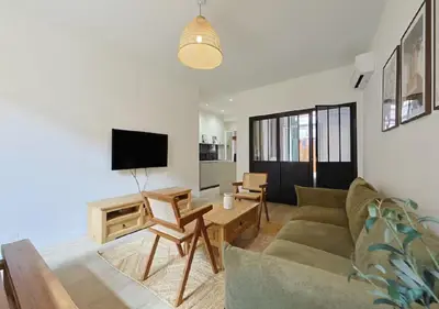 a living room with a couch and a tv at Élégance & confort au cœur du Vieux Nice in Nice