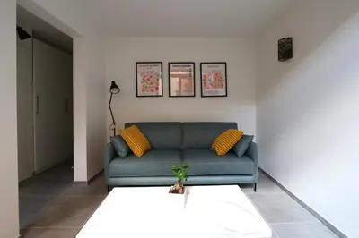 a living room with a blue couch and yellow pillows at Nümad Suites in Nice