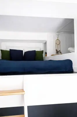 a white bed with blue sheets and green pillows at DeLuxe Studio Cosy, Promenade des Anglais, NICE CENTRE in Nice