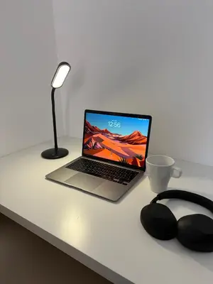 a laptop computer sitting on top of a desk with a lamp at Le Bonappart T3 Grande Terrasse in Nice