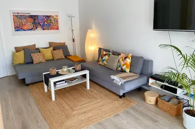 a living room with a couch and a table at 3 pièces 10 min de la mer et du tram in Nice