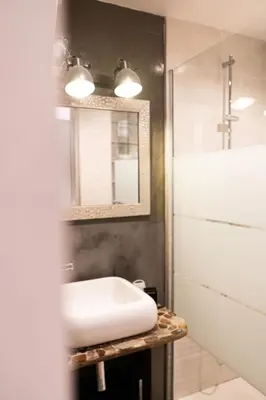 a bathroom with a white sink and a mirror at L'Adresse du Choeur - Vieux Nice in Nice