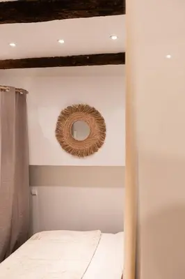 a bedroom with a bed and a mirror on the wall at L'Adresse du Choeur - Vieux Nice in Nice