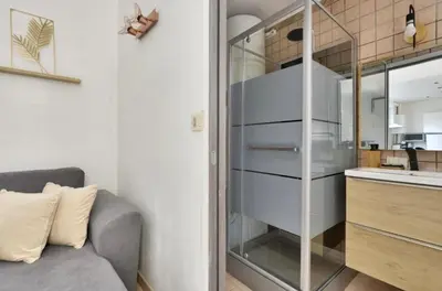 a living room with a couch and a kitchen at Studio Carré Or avec balcon in Nice