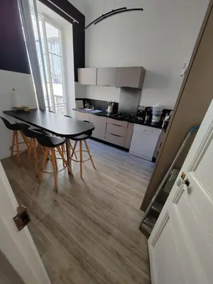 a kitchen with a table and chairs in a room at superbe chambre plein centre Nice climatisé direct aéroport via tram in Nice