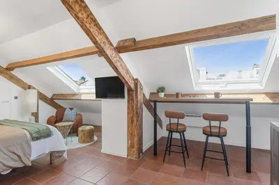 a bedroom with a bed and a desk and two stools at Studio sous les toits, Nice Centre in Nice
