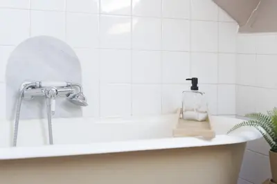 a bath tub with a sink with a soap bottle on it at Studio sous les toits, Nice Centre in Nice