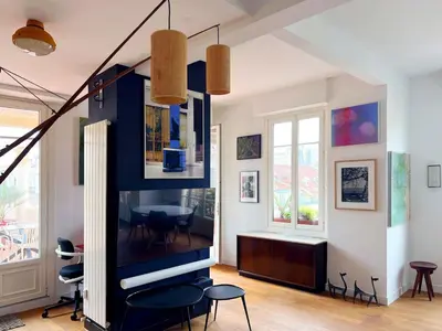 a living room with a large tv and chairs at Design et Art in Nice