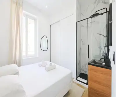 a white bedroom with a large bed and a shower at Splendide Appartement Neuf au Port de Nice in Nice
