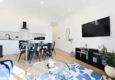 a living room with a dining table and a kitchen at Splendide Appartement Neuf au Port de Nice in Nice