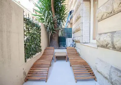 a row of wooden benches on a building with a table at Nid Douillet au Cœur de Nice avec terrasse et clim in Nice