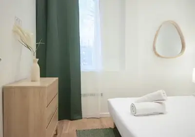 a bathroom with a white tub and a mirror at Nid Douillet au Cœur de Nice avec terrasse et clim in Nice