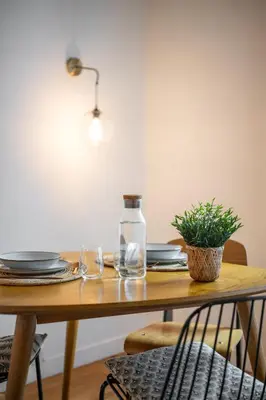 a wooden table with glasses and a plant on it at Les Palmiers, quiet and air-conditioned in Nice